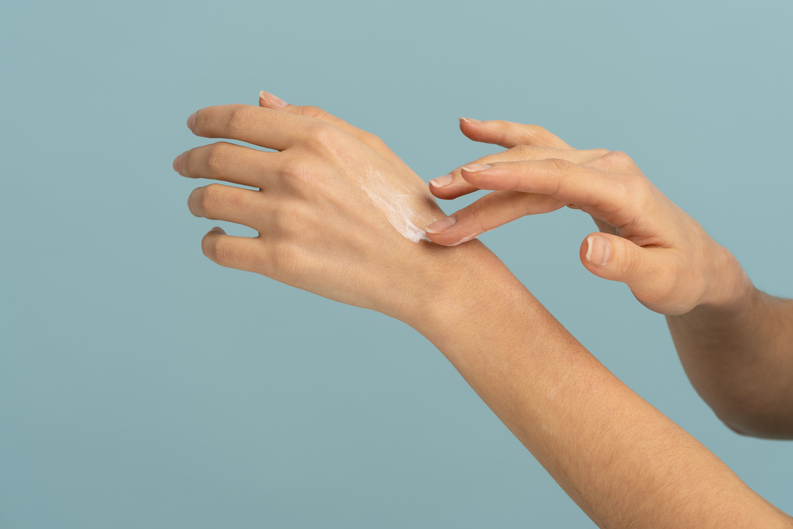 Person Applying Cream on Hand